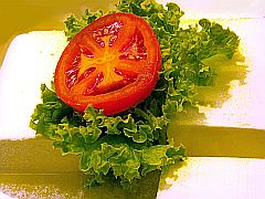 griechischer Schafskäse mit Salatblatt und Tomatenscheibe