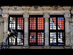Aufnahme der Spiegelung einer modernen Häuserfront in einem alten Fenster