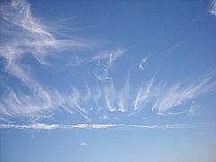 Weiße Cirrus-Strahlen vor blauem Sommer-Himmel