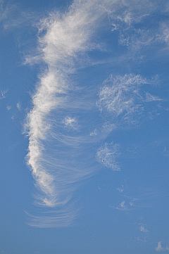 Turm aus weißen Schleierwolken vor strahlend blauem Himmel