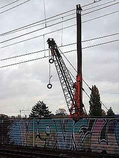 Baukran hinterm Lärmschutzwall mit Graffiti
