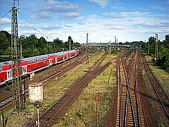 Industrie: Bild mit Schienennetz und Personenzug unter blauem Himmel
