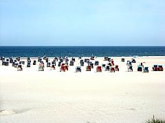 bunte Strandkörbe in weißem Sand bei herrlichstem Urlaubs-Wetter